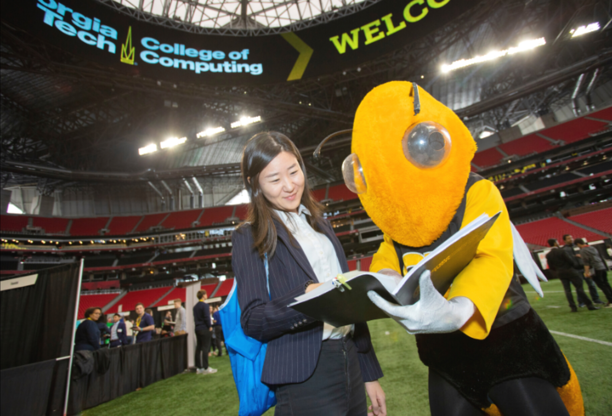 Georgia Tech mascot Buzz at career fair with student at Mercedes-Benz Stadium